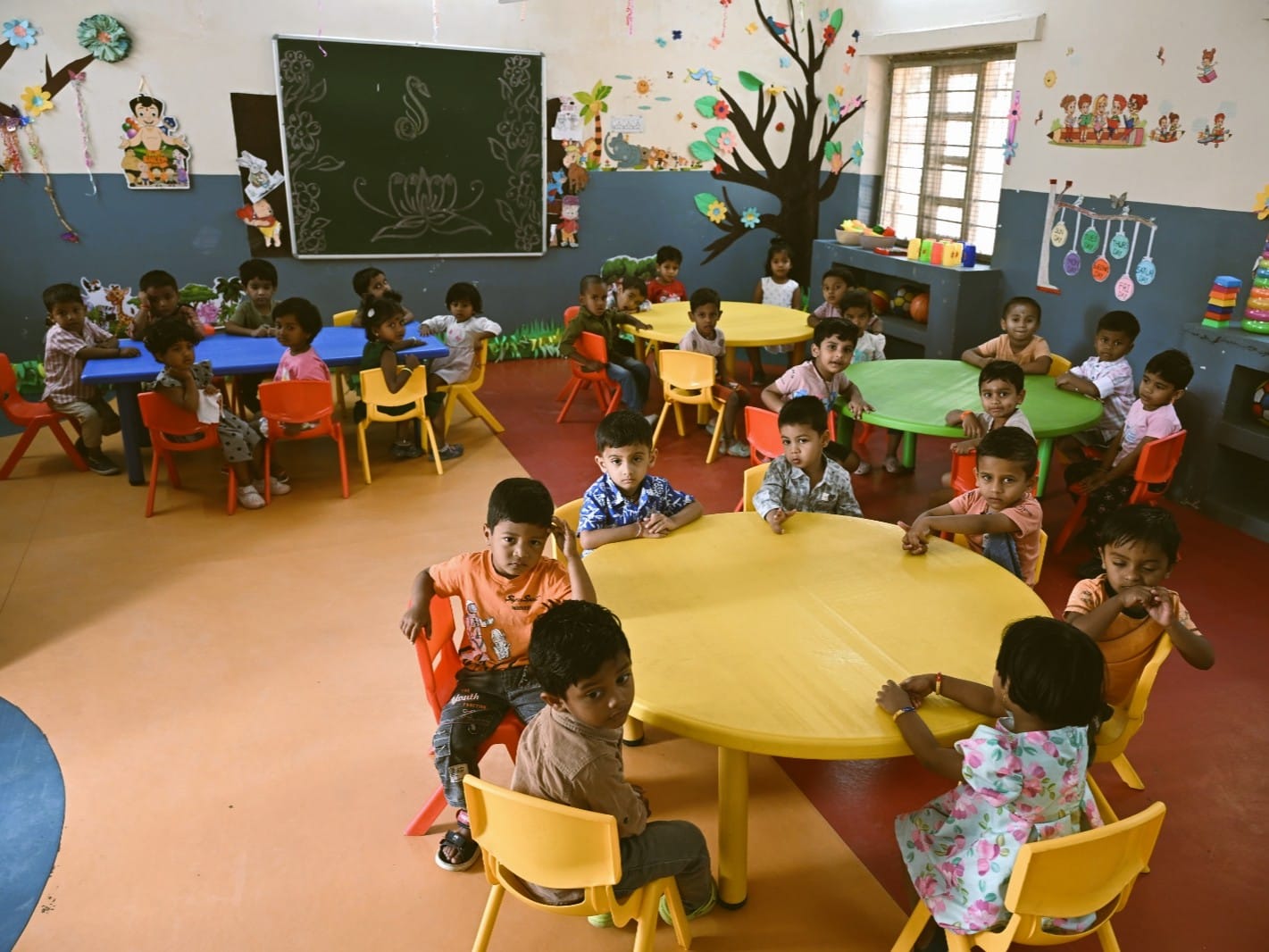 Young students at activity tables in a Gitanjali School classroom